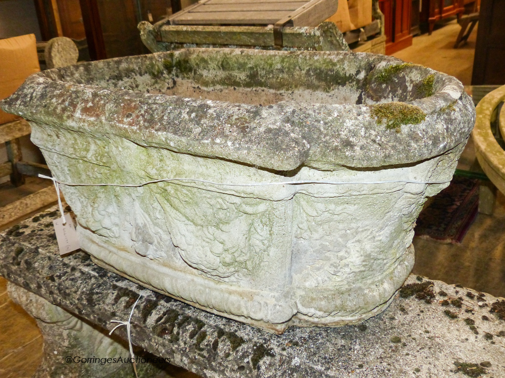 A pair of reconstituted stone shaped oval planters with swag decoration, width 80cm, height 42cm